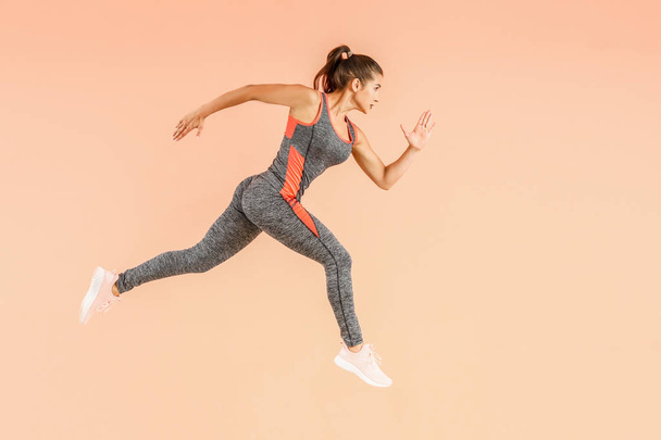 Running sporty woman on color background - Foto, imagen
