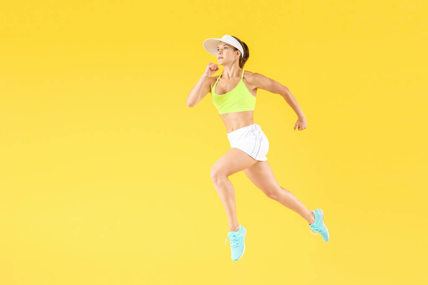 Running female tennis player on color background - Photo, Image