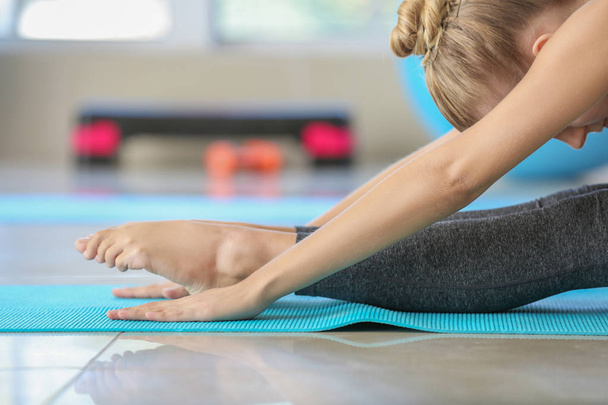 Junge Frau praktiziert Yoga im Fitnessstudio - Foto, Bild