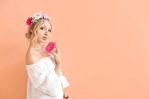 色の背景上の花の花輪と美しい若い女性 - 写真・画像