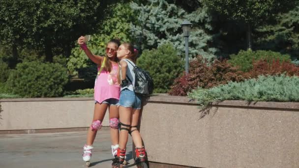 Girls rollerblading take a selfie on a smartphone - Metraje, vídeo