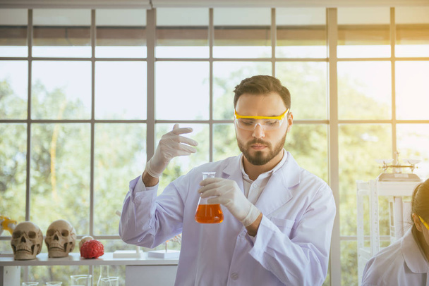 Scientifique homme travaillant test d'odeur et de mettre l'échantillon de produits chimiques médicaux dans le tube à essai au laboratoire
 - Photo, image