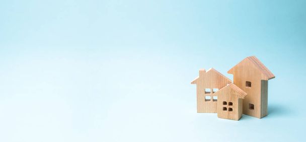 Wooden houses on a blue background. Wooden Toys. The concept of real estate and ownership, purchase of property. Farm, city, village, enterprise. Construction and improvement of buildings. banner - Fotoğraf, Görsel