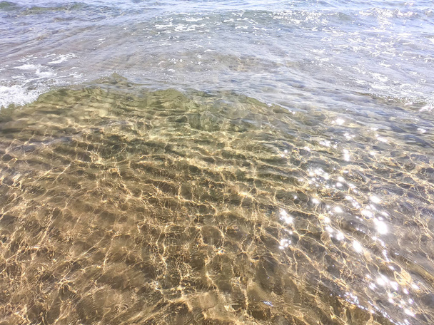 Textura čisté vody s písčitým dnem. Vlna na pobřeží nebo na moři. - Fotografie, Obrázek