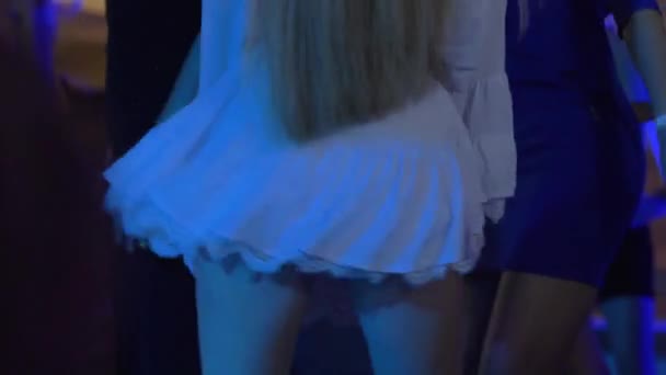 Tanzende Beute, Mädchen mit langen Haaren in weißen Kleidern dreht aktiv den Arsch auf der Tanzfläche, während sie ihren Körper bewegt - Filmmaterial, Video