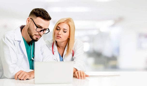 Doctors working with laptop computer in hospital. - Zdjęcie, obraz