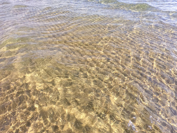 La textura del agua clara con fondo arenoso. Ola en la orilla del mar o el océano
. - Foto, Imagen