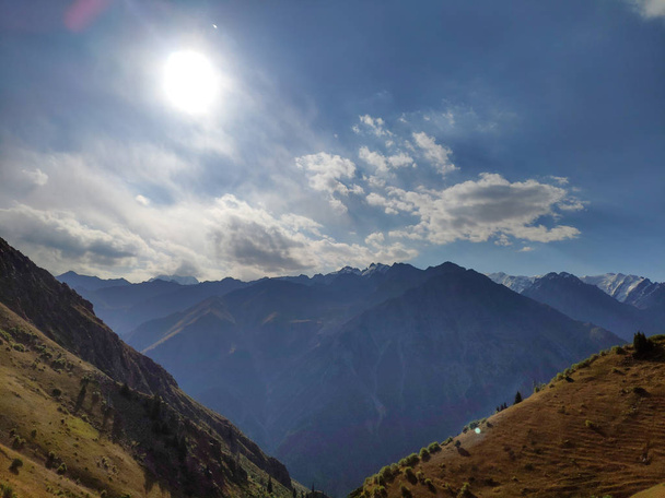 Cordillera Trans-Ili Alatau del sistema Tien Shan en Kazajstán cerca de la ciudad de Almaty. Picos rocosos cubiertos de nieve y glaciares en pleno verano bajo las nubes
 - Foto, imagen