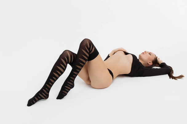 Beautiful woman laying in underwear in studio - Photo, Image