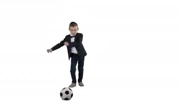 Resmi takım elbiseli sevimli bir çocuk beyaz arka planda bir topa vuruyor. - Video, Çekim