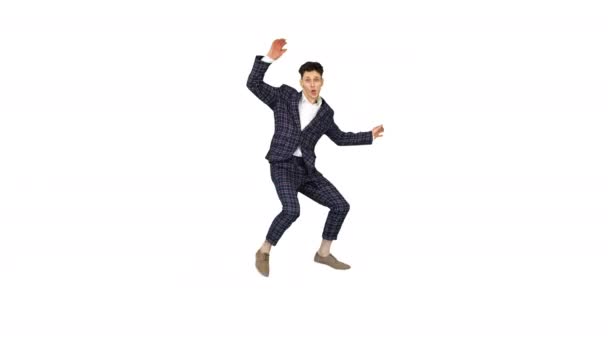 Young attractive male dancer in the strict business suit dancing making a split on white background. - Footage, Video