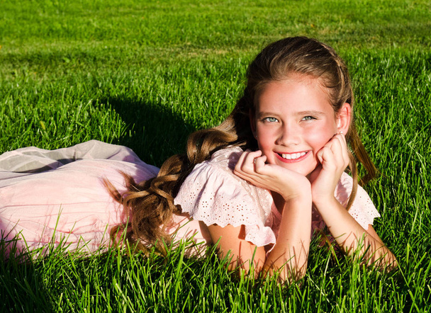 Adorable petite fille heureuse enfant couché sur l'herbe dans le parc
  - Photo, image
