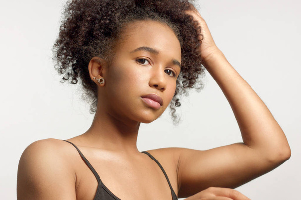 primer plano retrato de joven modelo de raza mixta con pelo rizado en el estudio con maquillaje natural neutro
 - Foto, imagen