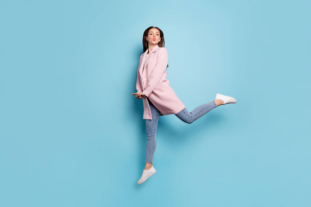 Full body photo of charming lovely girl jump have date send air kiss to her sweetheart wear season coat denim jeans isolated over pastel color background - Fotografie, Obrázek