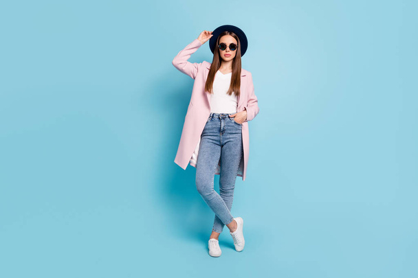 Full size photo of charming classy worker in eyeglasses eyewear touch her modern cap ready to decide work decision wear topcoat denim jeans isolated over blue color background - 写真・画像
