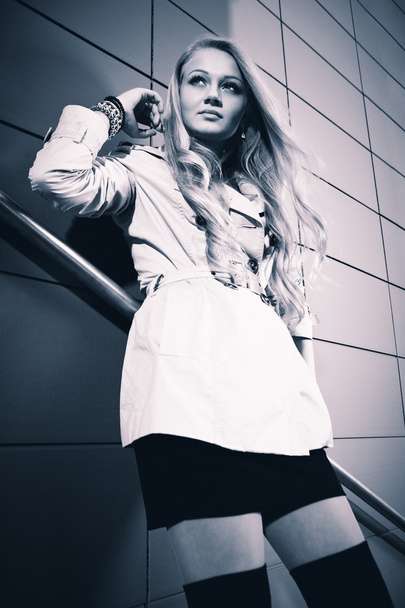 Young blonde beautiful lady on city stairs posing for beauty shots - 写真・画像