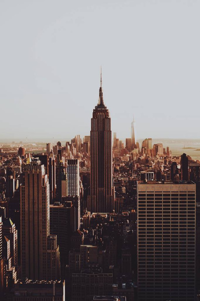 A vertical sepia shot of the skyline of New York with the famous Empire State building - Fotó, kép