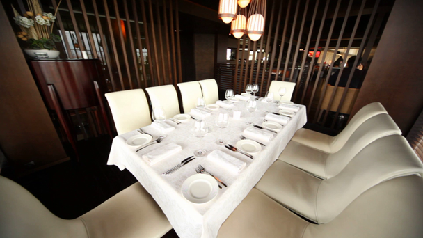 Decorated table for ten persons stands in corner of hall of restaurant - Footage, Video