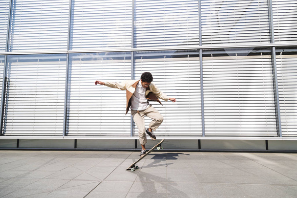 African american guy jumps and flips skate in air - Foto, afbeelding