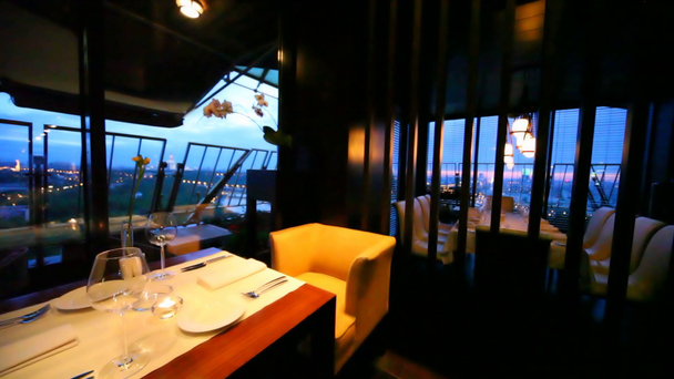 Weingläser und Kerzen stehen auf dekoriertem Tisch im Aufenthaltsraum des Restaurants - Filmmaterial, Video