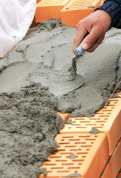 Cement or mortar, Cement mix with a trowel in a hand on the brick for  construction work. Stock Photo