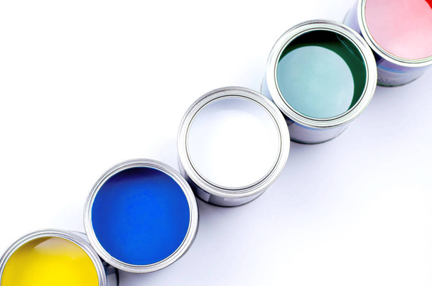 Five cans of multicolored paint on a white background. - Фото, изображение