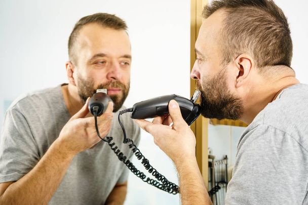 Man shaving trimming his beard - 写真・画像