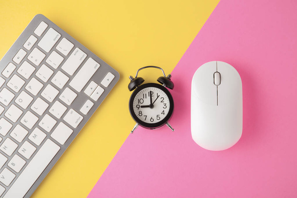 Bezprzewodowa klawiatura i mysz z zegarem na żółtym różowym tle - Zdjęcie, obraz