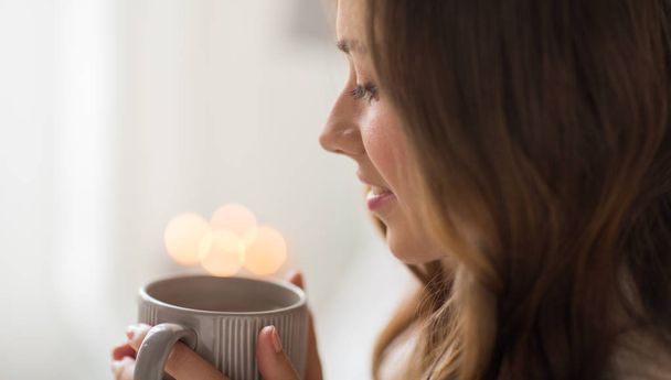 close up of happy woman with cup of coffee at home - Фото, изображение