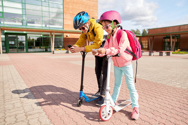 school children with smartphones and scooters - Foto, immagini