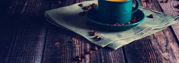 Cafe background with a green cup of espresso coffee standing on a linen napkin with a retro coffee grinder old book. Retro style Nashville. Tonted image.  - Fotoğraf, Görsel