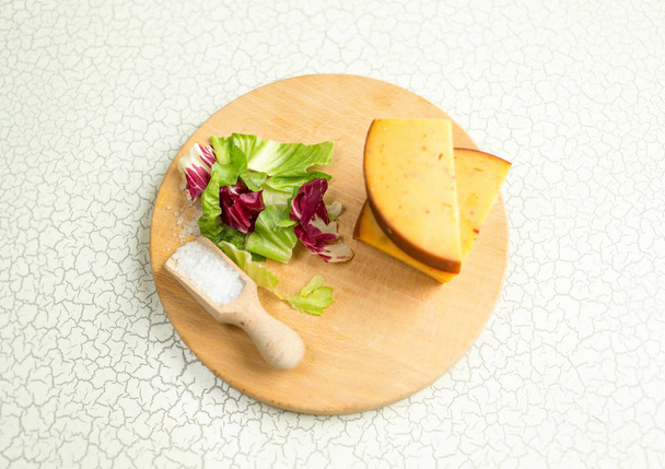Свежий салат, сыр, ветчина и морская соль на разделочной доске. Межконтинентальный завтрак в отеле
. - Фото, изображение