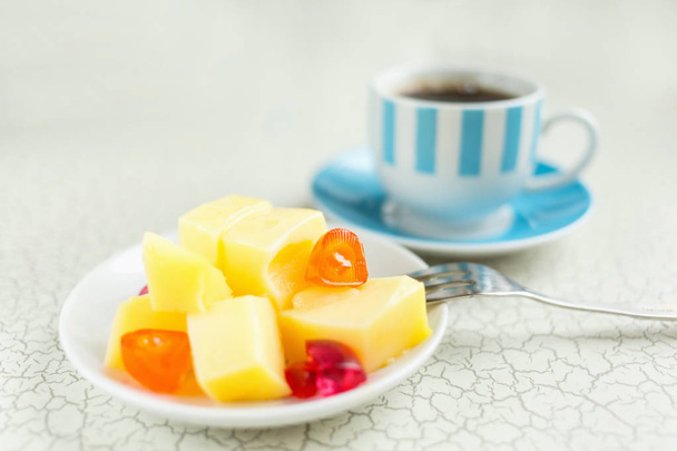 Κρέμα με γάλα και καραμέλα φρούτων για επιδόρπιο. Φέτες πορτοκάλι και καφέδες για πρωινό. - Φωτογραφία, εικόνα