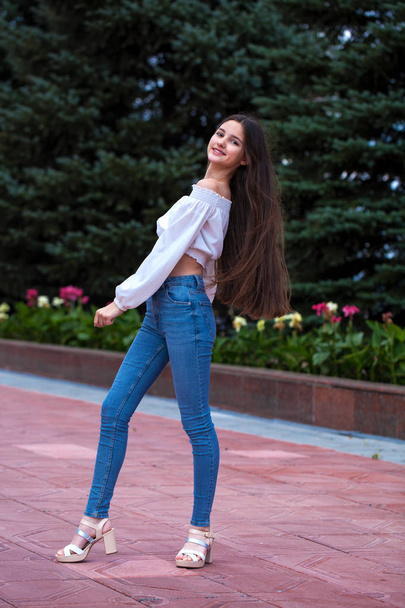 Pretty stylish brunette girl in blue jeans and white blouse  - Foto, Imagen