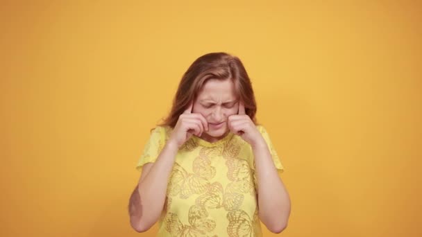brunetta ragazza in giallo t-shirt su isolato sfondo arancione mostra emozioni
 - Filmati, video