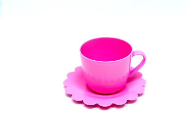 白い背景に孤立したピンクのプラスチックカップ - 写真・画像