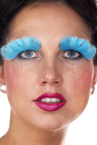 Lady posing in studio for portrait with blue feather eye lashes - Фото, изображение