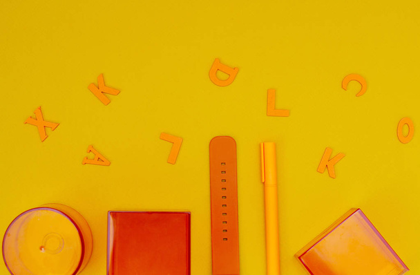 3D geometrické průhledné oranžové tvary - rovnoběžník, válec a kostka. Sledujte popruh a kuličkové pero na žlutém pozadí. - Fotografie, Obrázek