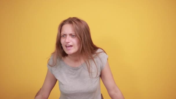 brunetta ragazza in grigio t-shirt su isolato sfondo arancione mostra emozioni
 - Filmati, video