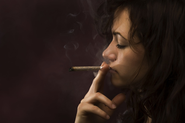 Young woman smoking marihuana - 写真・画像