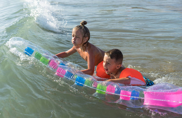 glücklicher Lebensstil der Familie. Kinder springen und planschen vor Spaß in brechenden Wellen. Bruder und Schwester - Foto, Bild