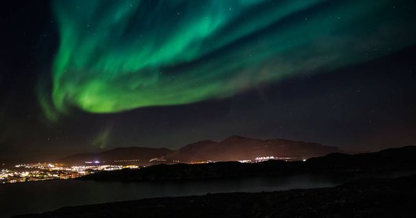 Masivas luces verdes del norte brillando sobre la ciudad de Nuuk, Groenlandia
 - Foto, imagen