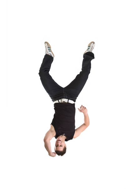 Fitness man in black trousers and shirt jumping and posing in studio for photos - Foto, imagen