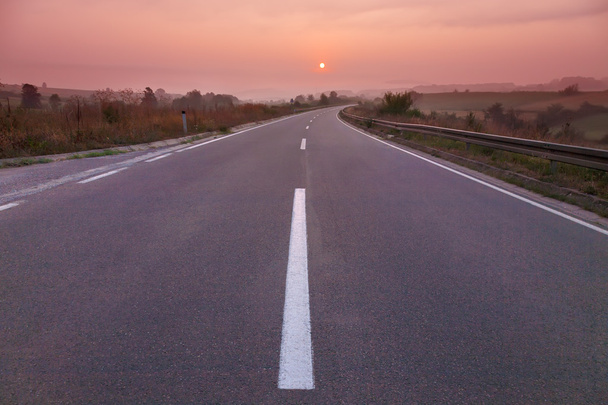 rijden op lege weg bij zonsopgang - Foto, afbeelding