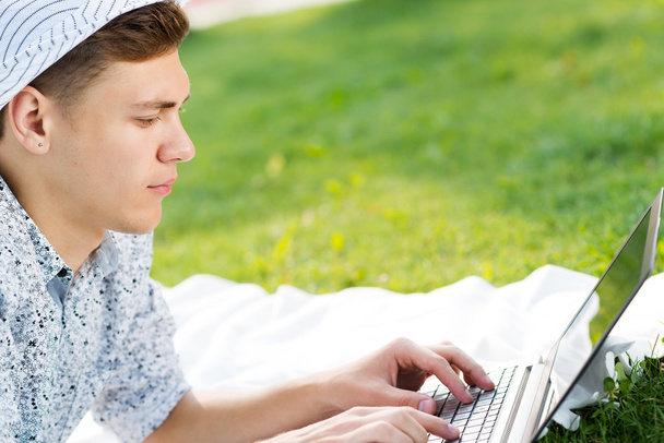 young man working in the park with a laptop - Foto, imagen