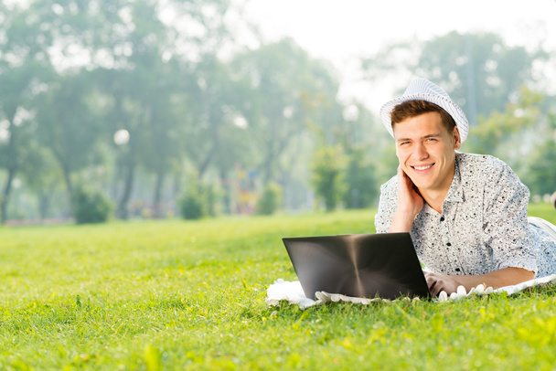 młody człowiek pracujący w parku z laptopem - Zdjęcie, obraz