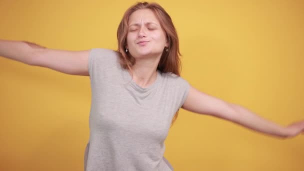 brunetta ragazza in grigio t-shirt su isolato sfondo arancione mostra emozioni
 - Filmati, video
