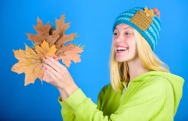 Skincare routine for autumn. Enjoy autumn season. Autumn skincare tips. Bright moment. Skincare and beauty tips. Active leisure and rest autumn season. Woman wear knitted hat hold fallen leaves - Photo, Image