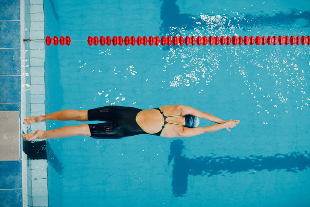 Mujer joven nadadora saltando en la piscina
 - Foto, imagen