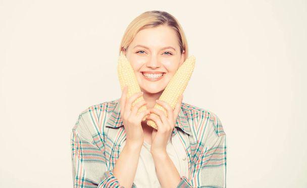 Food bring happiness. Woman hold yellow corn cob white background. Corn harvest. Girl hold ripe corn. Food vegetarian and healthy natural organic products. Vegetarian menu. Healthy food concept - Foto, Bild